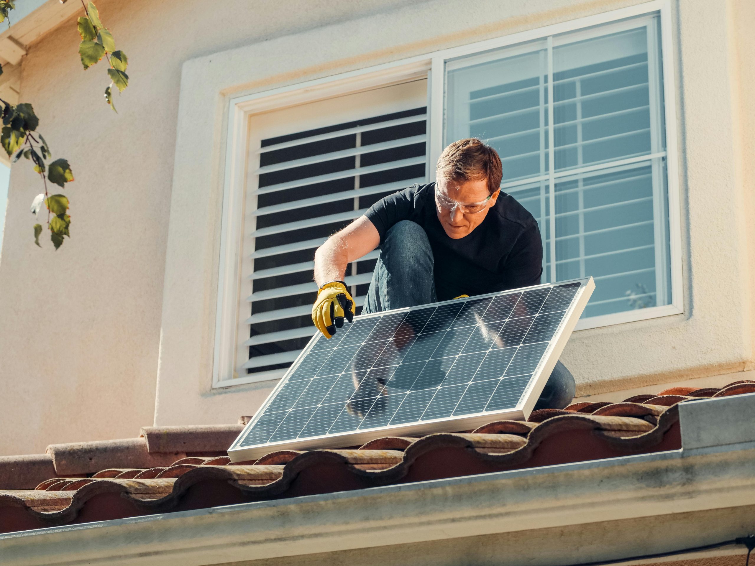 man installing solar panels on a roof
